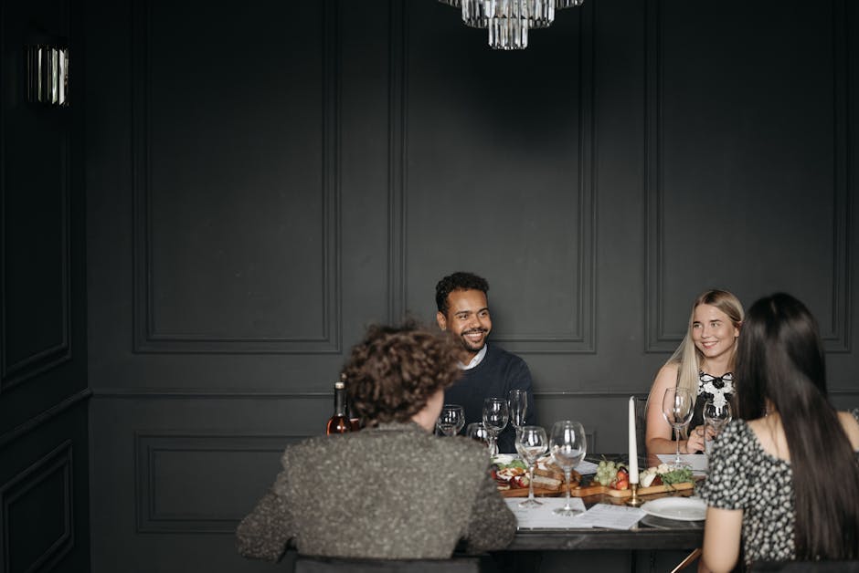 A group of friends enjoying a sophisticated dinner setting, sharing a conversation indoors